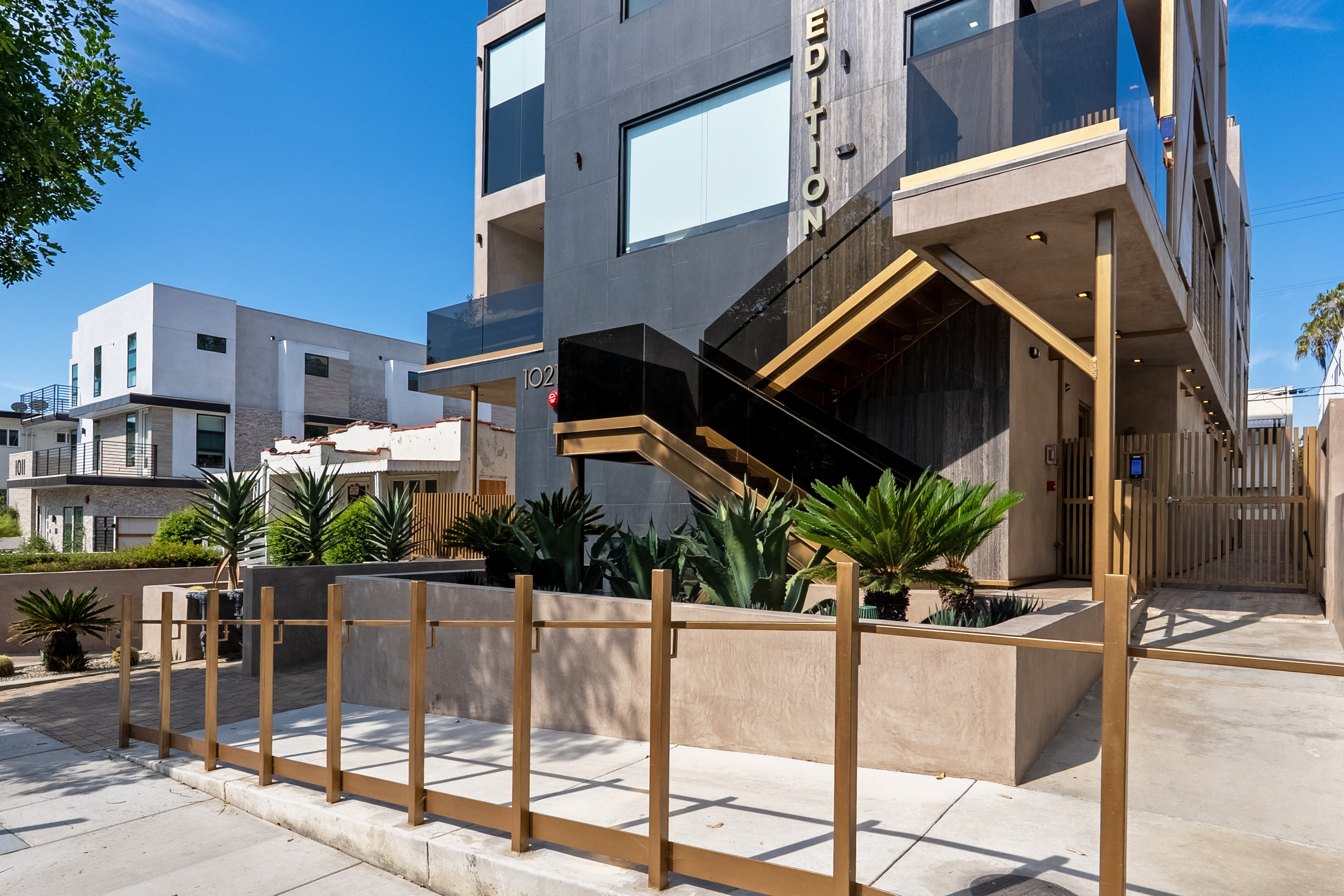 Gated street frontage and brass pedestrian gate at 1021 N Ogden Drive